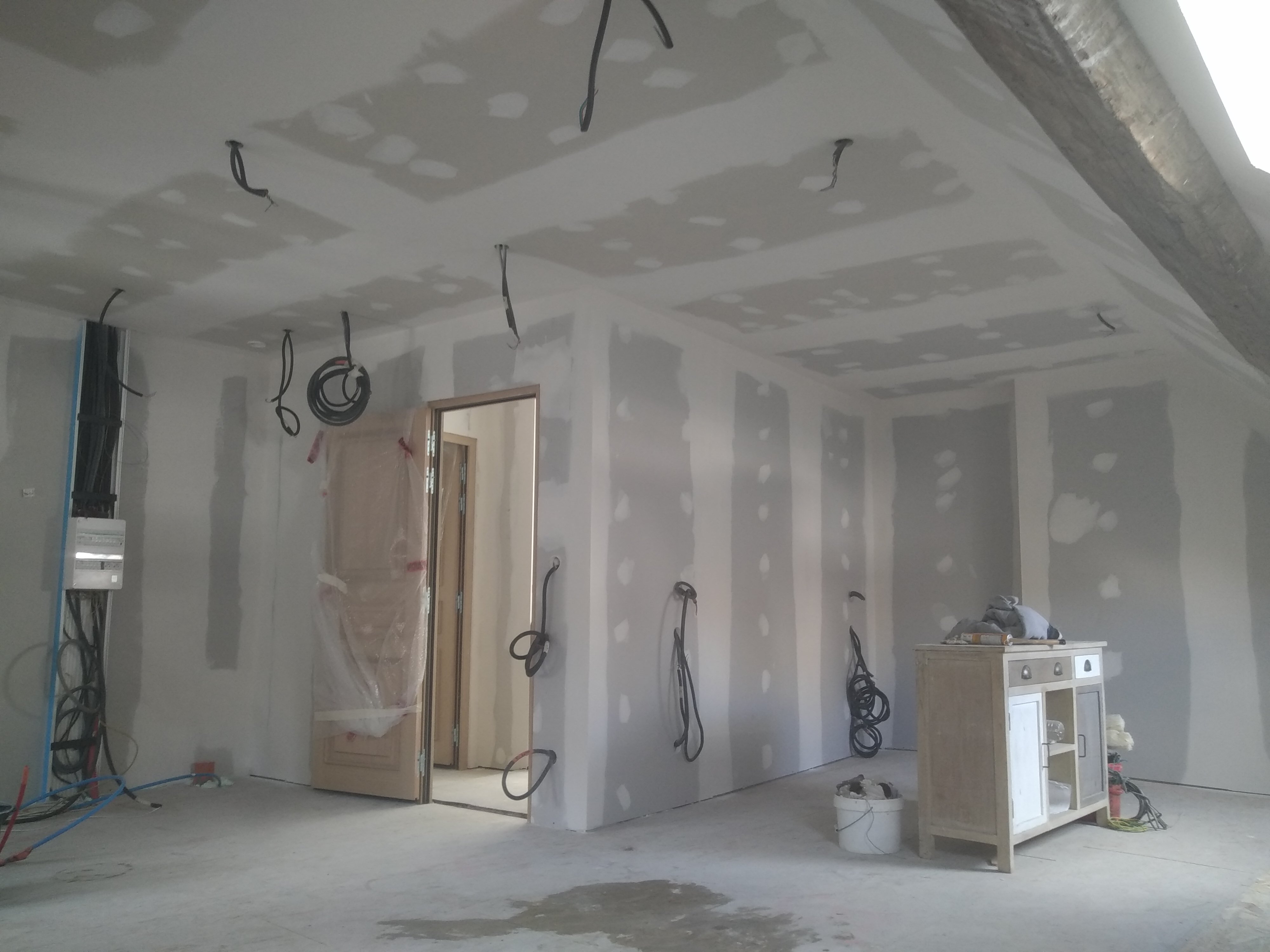 Mur en cours de rénovation, avec plaque de plâtre et finition par un plâtrier plaquiste.
